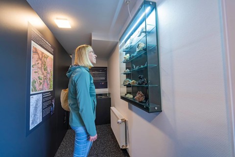 Glass showcase with stones and information boards in a museum room, family festival in Neubulach,