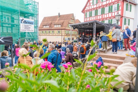 Colourful street festival with lots of people, stage and traditional houses, family festival in