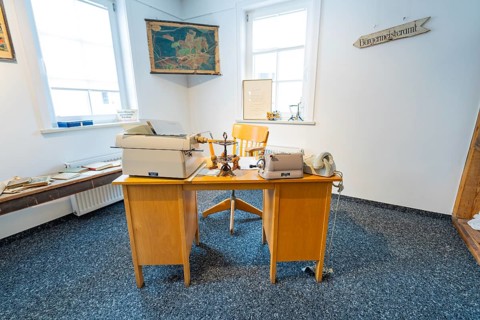 Historic office with old typewriters and telephones in a bright room, family party in Neubulach,