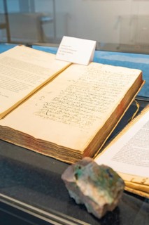 Old book with handwritten notes displayed in a showcase, Family Festival in Neubulach, Calw