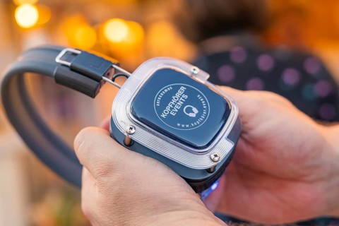 Advanced headphones are held in one hand and looked at, Calw railway station festival, Black