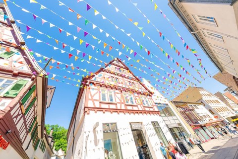 Cheerful sight of a decorated city street with colourful flags, Calw station festival, Black