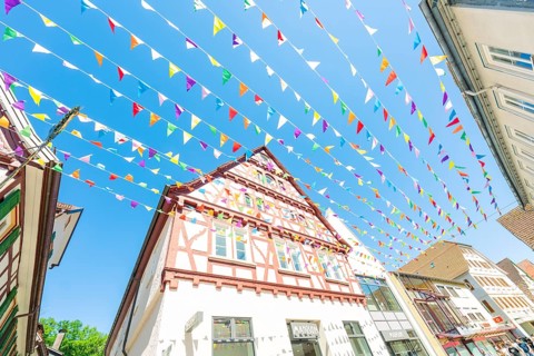 Colourfully decorated town with half-timbered houses and colourful flags in summer, Calw station