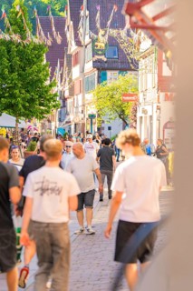 Lively city street full of people on a sunny day, Calw railway station festival, Black Forest,