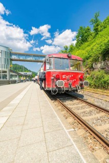 Red train waiting on the track under a blue sky, Calw railway station festival, Black Forest,