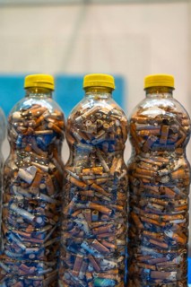 Plastic bottles are filled with discarded cigarette butts, highlighting the pervasive issue of