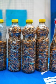 Plastic bottles filled with cigarette butts collected during a beach cleanup, highlighting
