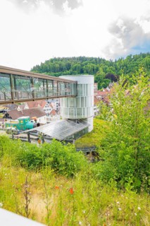 A modern bridge structure in a green landscape with a town in the background, Zob extension with
