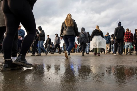 Festival visitors are reflected in a puddle at the Rock am Ring Festival on Sunday, Nürburgring