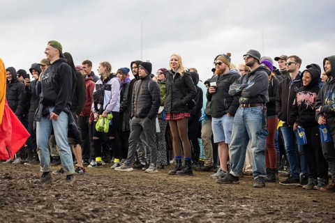 Festival-goers stand in the mud in front of the Atmos Stage at the Rock am Ring Festival on Sunday,