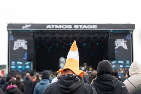 Festival visitors with a hat shaped like a cone in front of the Atmos Stage at the Rock am Ring
