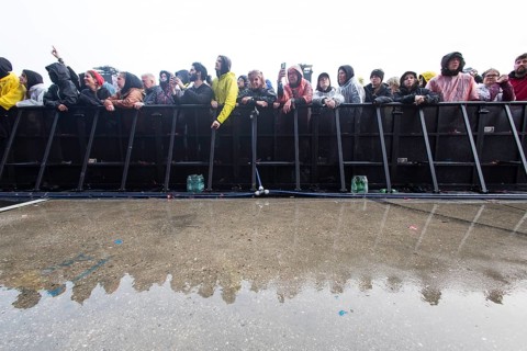 Festival visitors at the barrier are reflected after heavy rain at the Rock am Ring Festival on