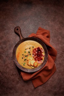 Pumpkin cream soup, curry, fried bacon, bruschetta chips, micro-greens, top view, no people