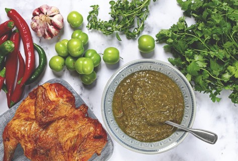 Tkemali sauce, made from green cherry plum, with ingredients on the table, tobacco chicken, top