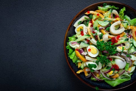 Salad with squid, fresh cucumber, eggs, sweet pepper, red onion, with dressing, homemade, no people