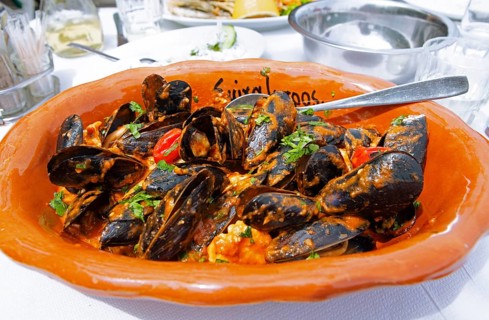 Mussels saganaki or mussels with tomato sauce and feta, typical Greek food, Pelion peninsula or