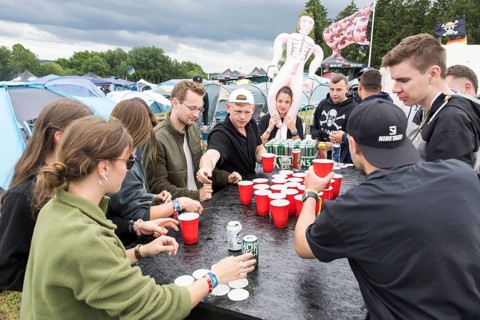 Festival visitors play a drinking game on a campsite at the Rock am Ring Festival on Saturday,