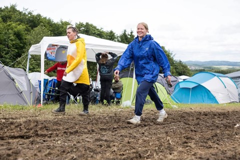 Two festival visitors walk through mud on a campsite at the Rock am Ring Festival on Saturday,