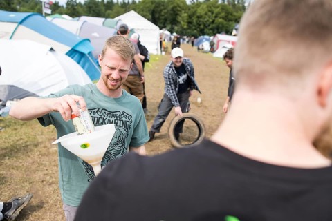 Festival visitors drinking from a funnel on a campsite at the Rock am Ring Festival on Saturday,