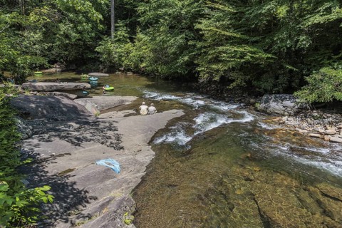 Senior couple watches children floating down the Hiawassee River on inflatable rafts near