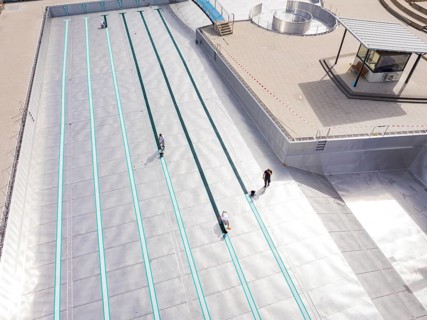 High-angle shot of a swimming pool under construction with workers, renovation of the swimming