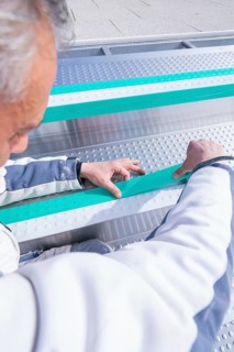 Worker adjusts stripes in the swimming pool with his hands, renewal of the swimming lines, Calw