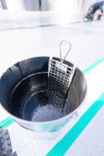 Close-up of a wet metal bucket with grid insert, shiny and detailed, renewal of the swimming lines,