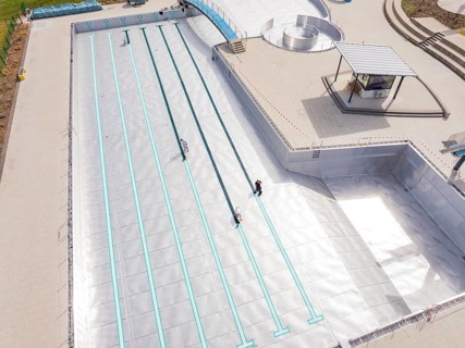 High-angle shot of an empty swimming pool under construction with metal walls, renewal of the
