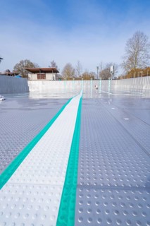 View along an empty swimming pool with striking stripes in the sun, renewal of the swimming lines,