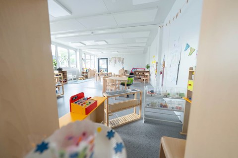 Light-flooded kindergarten room with toys and wall decorations, transitional containerised daycare