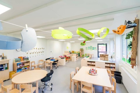 Creatively designed learning space with colourful paper decorations and wooden furniture,