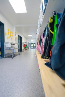 Corridor with shelves full of bags and a trolley, bright and organised atmosphere, transitional