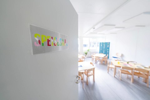 Bright classroom view through an open door with the sign 'Spessart', transitional daycare centre in