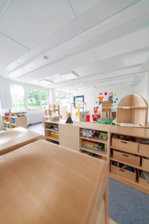 Versatile and bright room with furniture, shelves and toys, transitional daycare centre in
