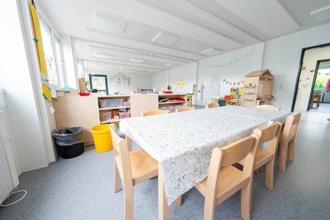 Inviting table area in the kindergarten with decorations and toys, transitional containerised