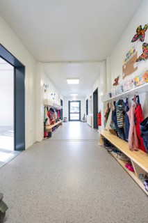 Bright corridor in a kindergarten full of children's clothes and colourful decorations,