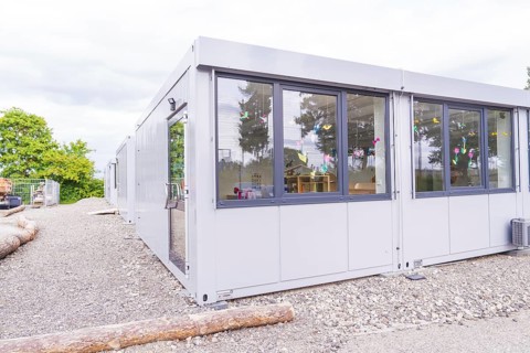 Exterior view of a modern modular building with decorated windows, transitional daycare centre in