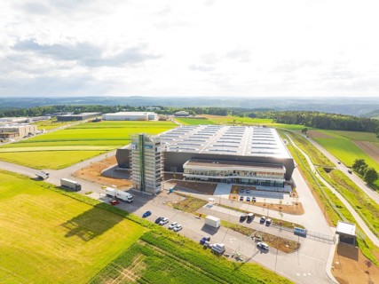 Large industrial facility in a rural setting with vehicles and wide fields, ING Park development
