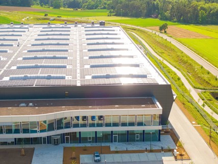 Roof of a large building with solar modules, surrounded by rural landscape, ING Park development