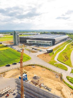 Large industrial building under construction with crane in rural surroundings, ING Park development