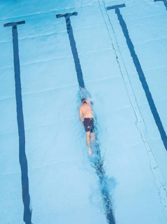 A swimmer in a large pool, concentrating on swimming his laps, Calw outdoor pool, Black Forest,