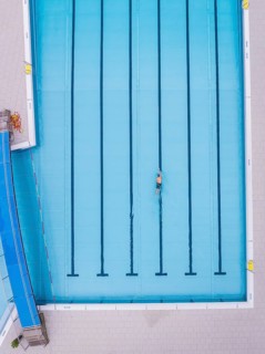 A swimmer in an empty swimming pool, bird's eye view, Calw outdoor pool, Black Forest, Germany
