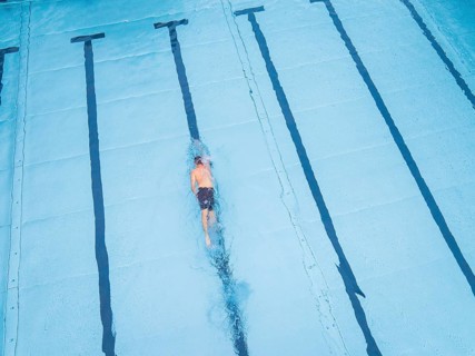 A single swimmer in the pool, calmly and steadily swimming his laps, Calw outdoor pool, Black