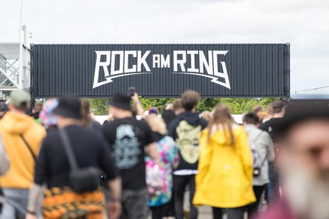 Festival visitors in front of a container with Rock am Ring logo at the Rock am Ring Festival on