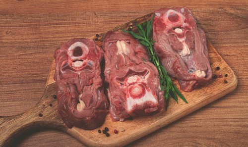 Raw steak, calf's neck on the bone, fresh meat, on the cutting board, top view, no people