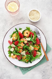 Fresh shrimp salad with arugula, grapefruit, and parmesan served in a bowl