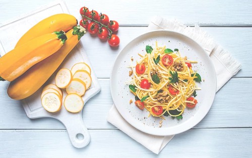 Yellow zucchini salad, with cherry, vegetarian food, sliced into strips, homemade