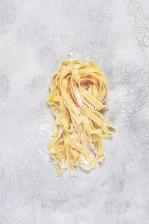 Raw tagliatelli pasta, homemade, top view, no people, rustic, food concept