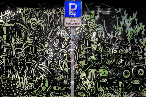 Parking sign in front of a graphite wall