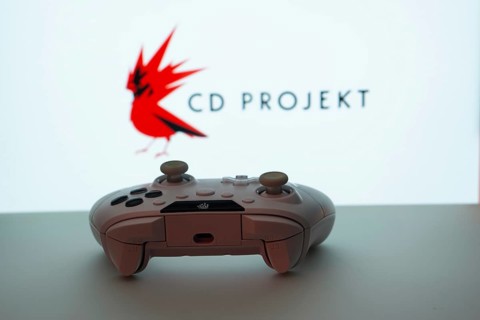 Dhaka, Bangladesh- 08 Apr 2025: A gaming controller in front of a CD Projekt screen